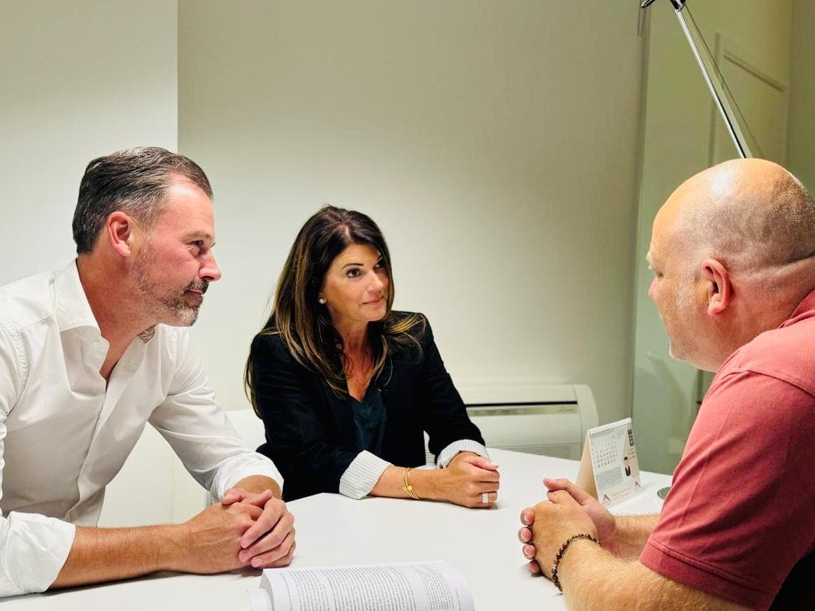 Professionele consultatie met drie personen rond een tafel in moderne kantooromgeving